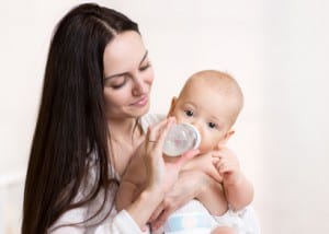 Mother gives to drink water baby from bottle